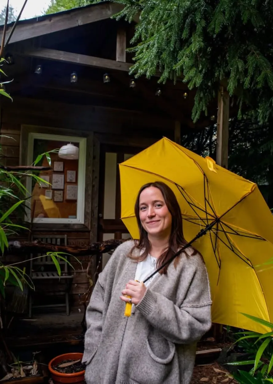 Abi with a yellow umbrella outside the cabin